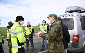 Plukovník Holý rozmlouvá se smíšenou hlídkou policie a armády na stanovišti.